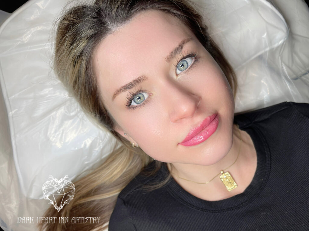 A woman with blue eyes in her home, laying on a bed.