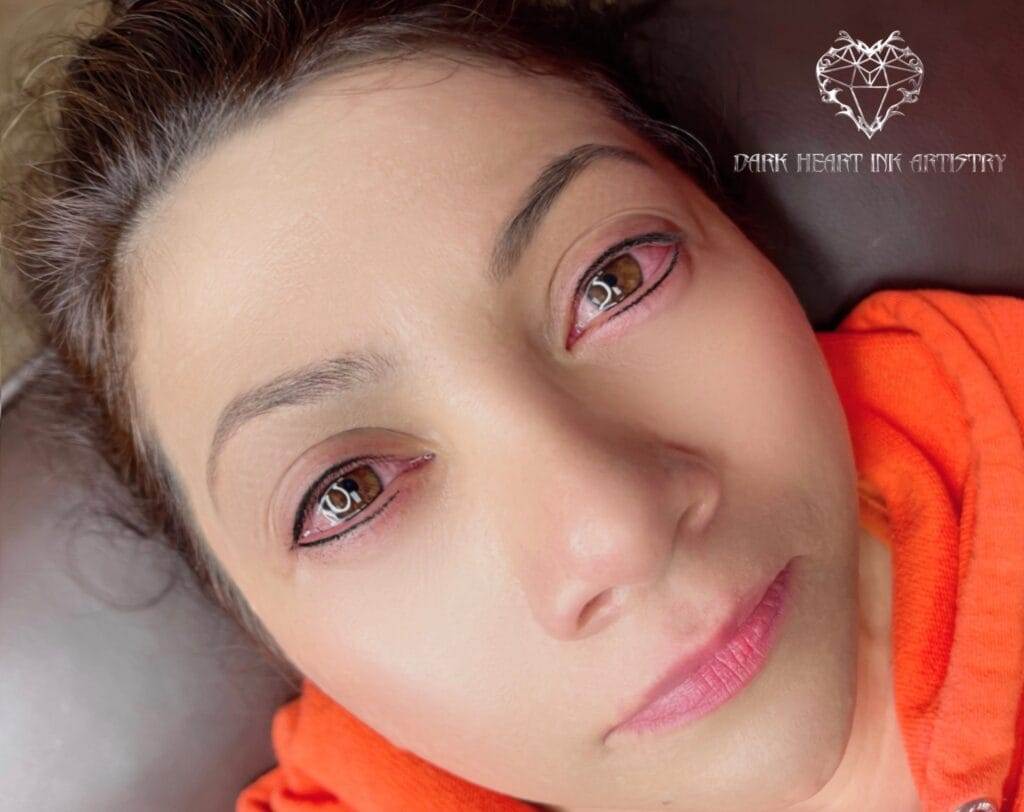A woman with pink eyes is lounging in a gallery.
