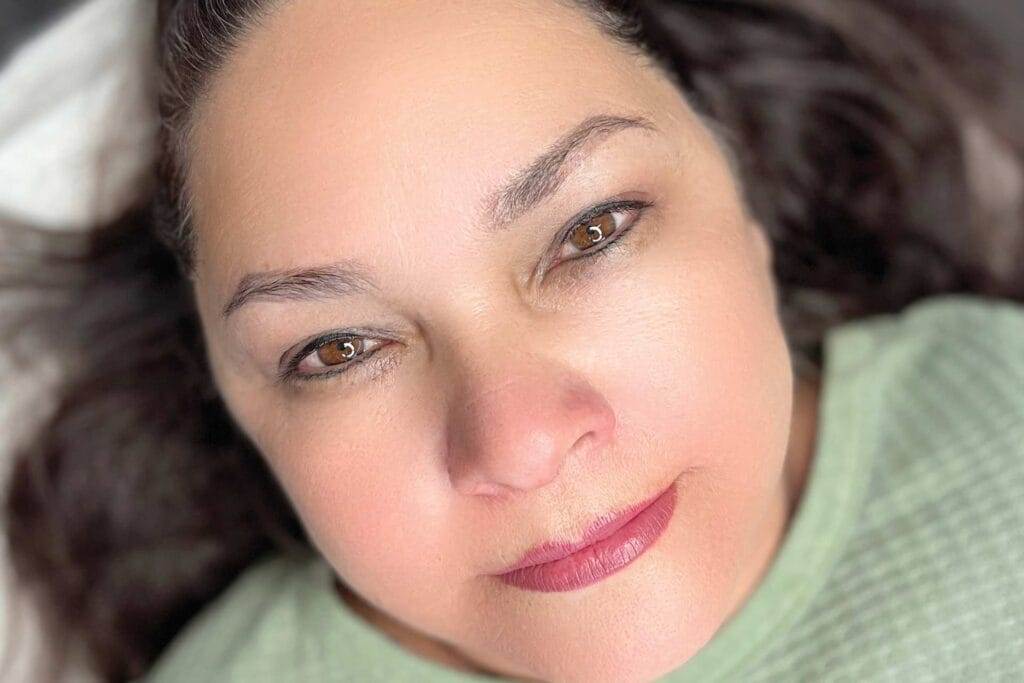 A close up of a woman laying on a bed.
