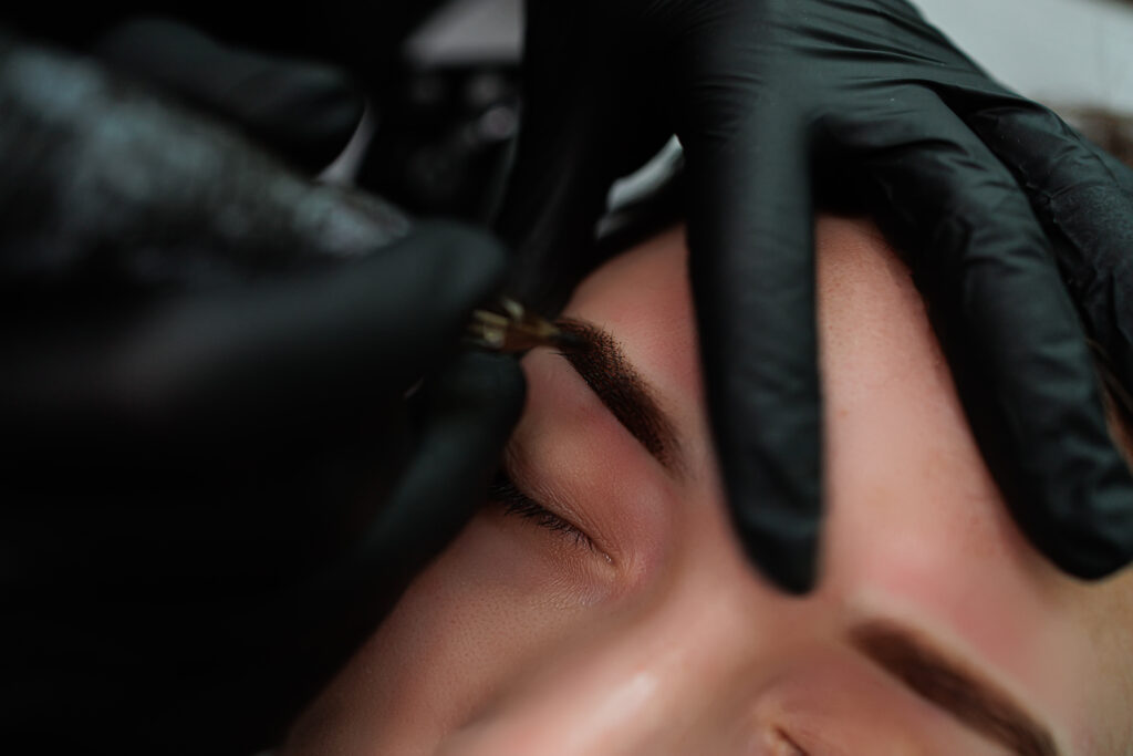 A woman gets her eyebrows tattooed at a gallery.